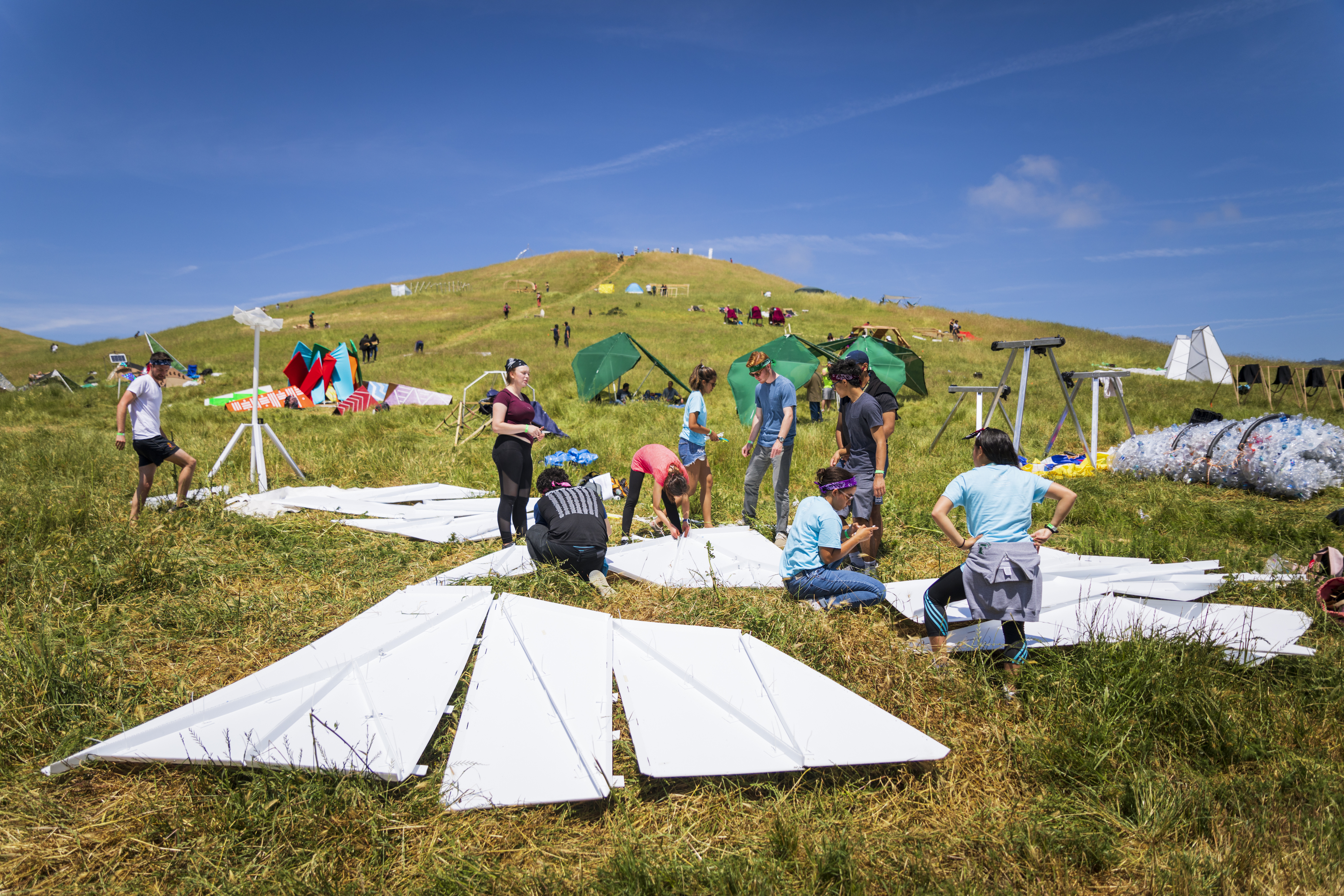 A team of Cal Poly students lays out materials for their structure at the 2019 Design Village competition in Poly Canyon. Photo by Joe Johnston.