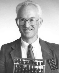 A black and white photo of Professor Zane Motteler holding an abbacus
