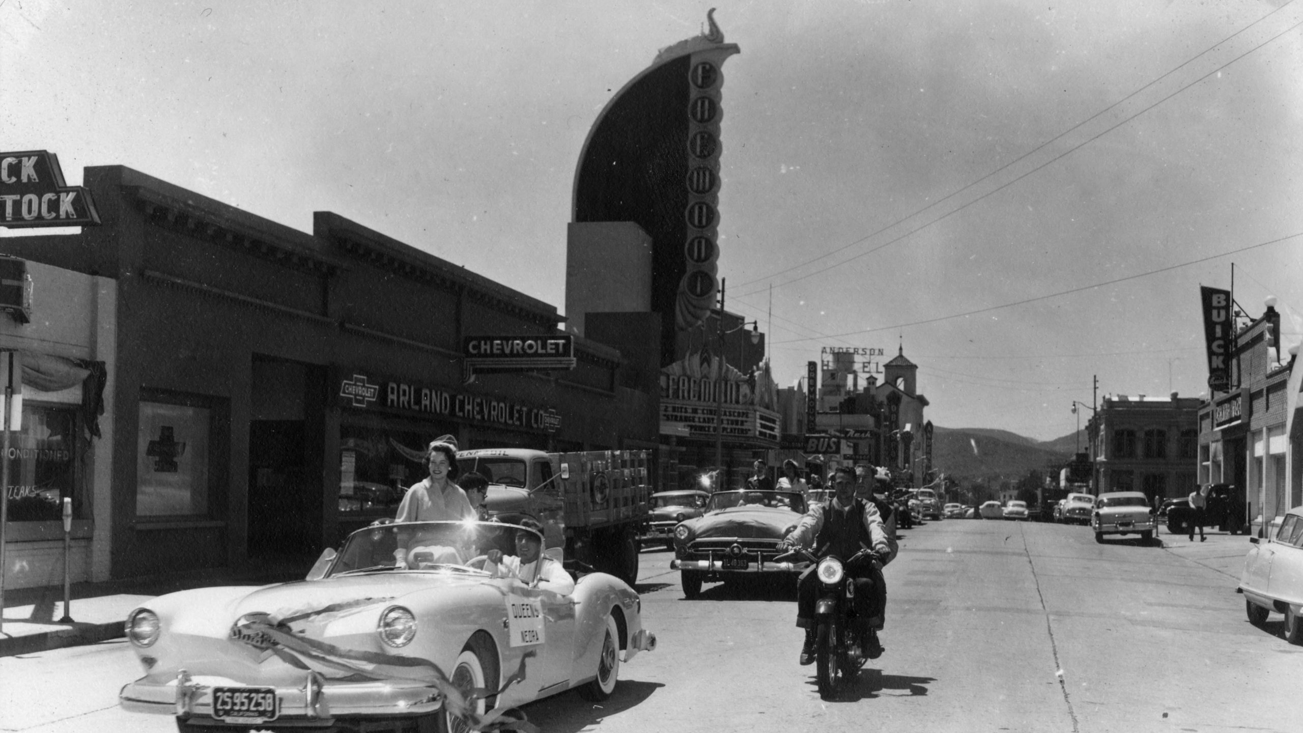Cars parade down Monterey Street in front of the Fremont Theater in 1955. Photo courtesy of University Archives.