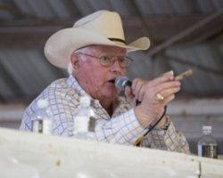 Alumnus Jim Glines wears a cowboy hat while he leads an auction.