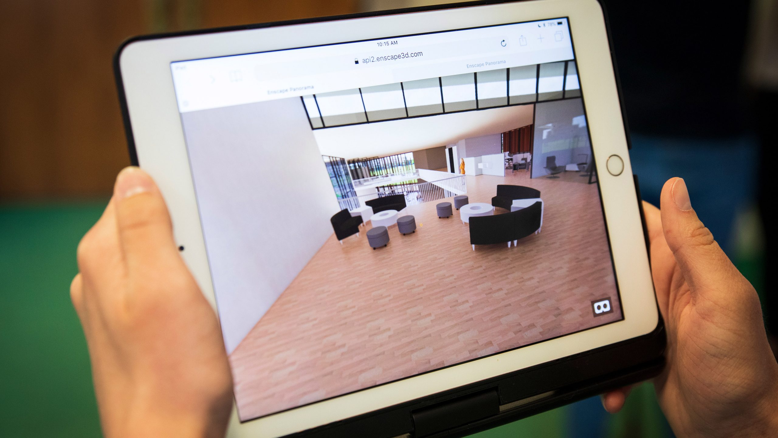 Hands holding a tablet displaying a student's virtual rendering of a building designed for Paradise, CA. Photo by Joe Johnston.