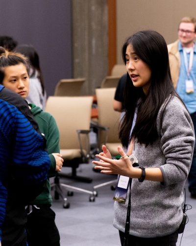 Selynna Sun speaking with hackathon participants at a team mixer