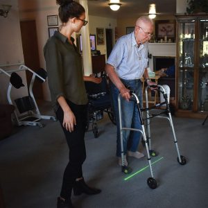 Sidney Collin stands besides Jack Brill as he tests the Gaitway device on his walker in his home