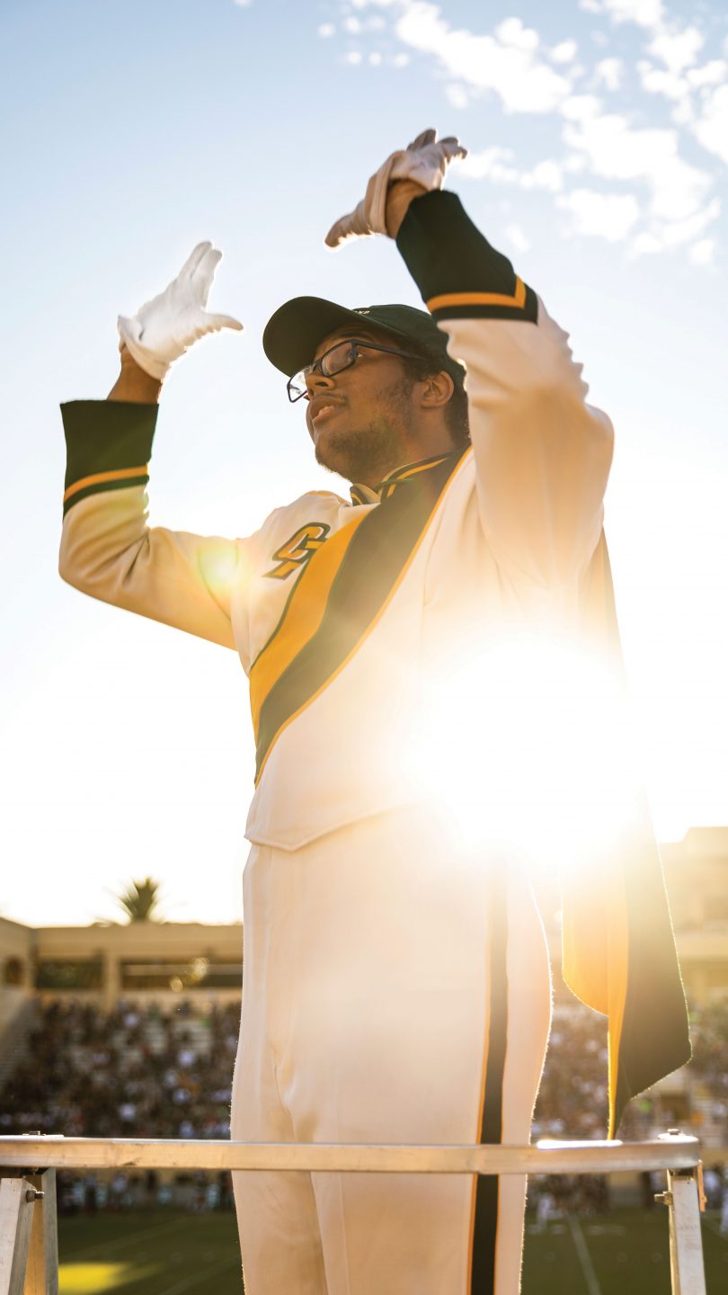 Drum major Ben Howard conducts the Mustang Band in the stands of Spanos Stadium