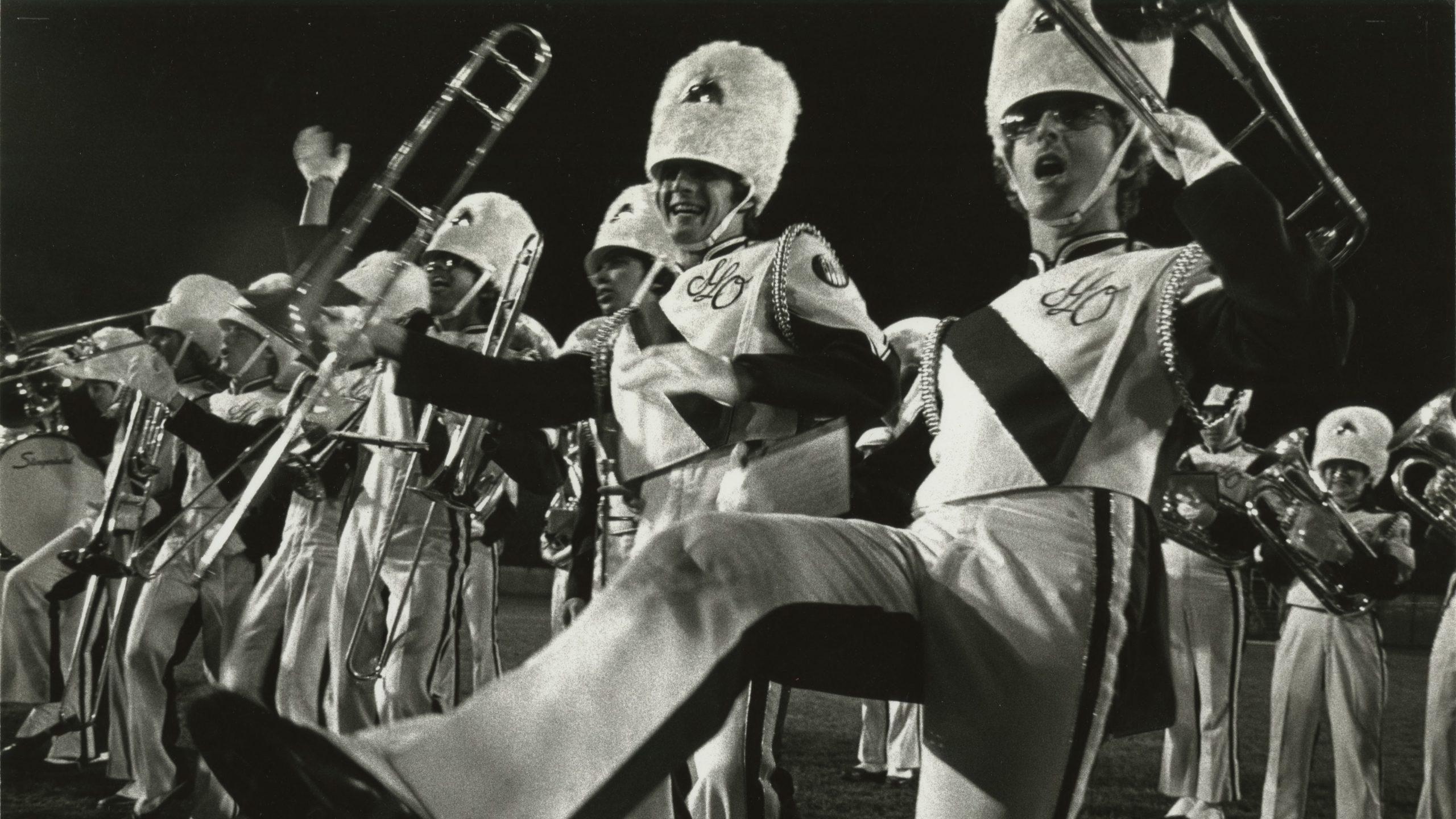 A black and white photo of Mustang Band members performing in 1983.