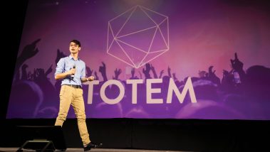Tal Kornfeld speaks in front of a slide with the Totem logo while making a pitch during the Center for Innovation and Entrepreneurship's Demo Day event