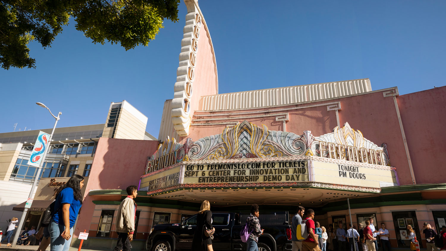 The marquee of the Fremont Theater announces the Cal Poly Center for Innovation and Entrepreneurship's Demo Day as patrons walk into the theater