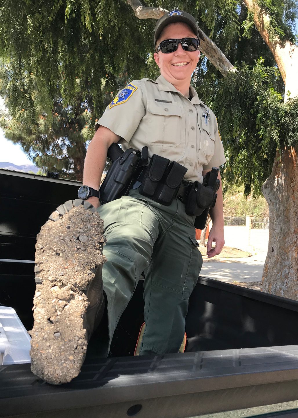 Game warden Anastasia Norris displays tar on the sole of her boot in Lake Elsinore, California
