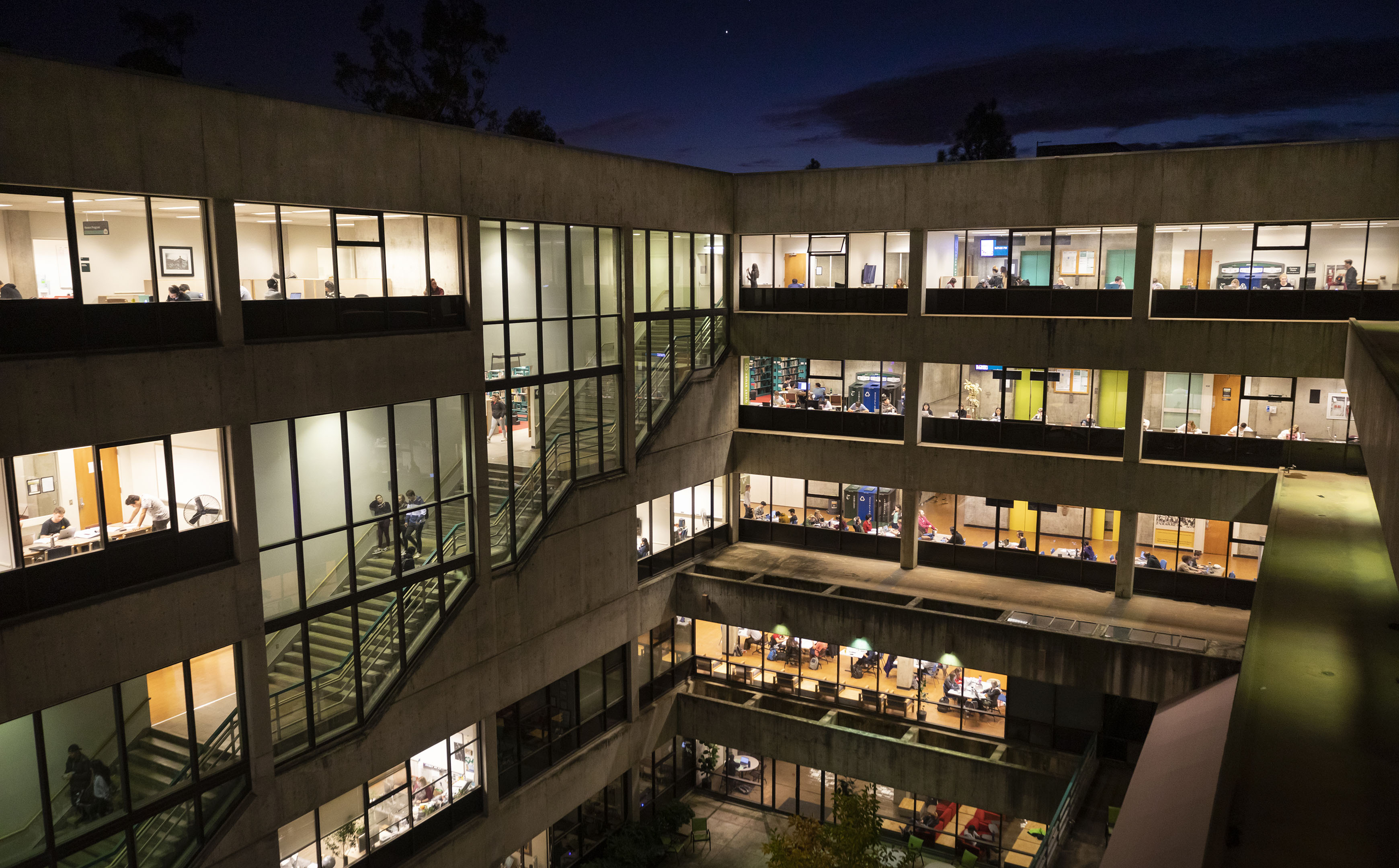 The atrium of Cal Poly's Kennedy Library lit and filled with students studying