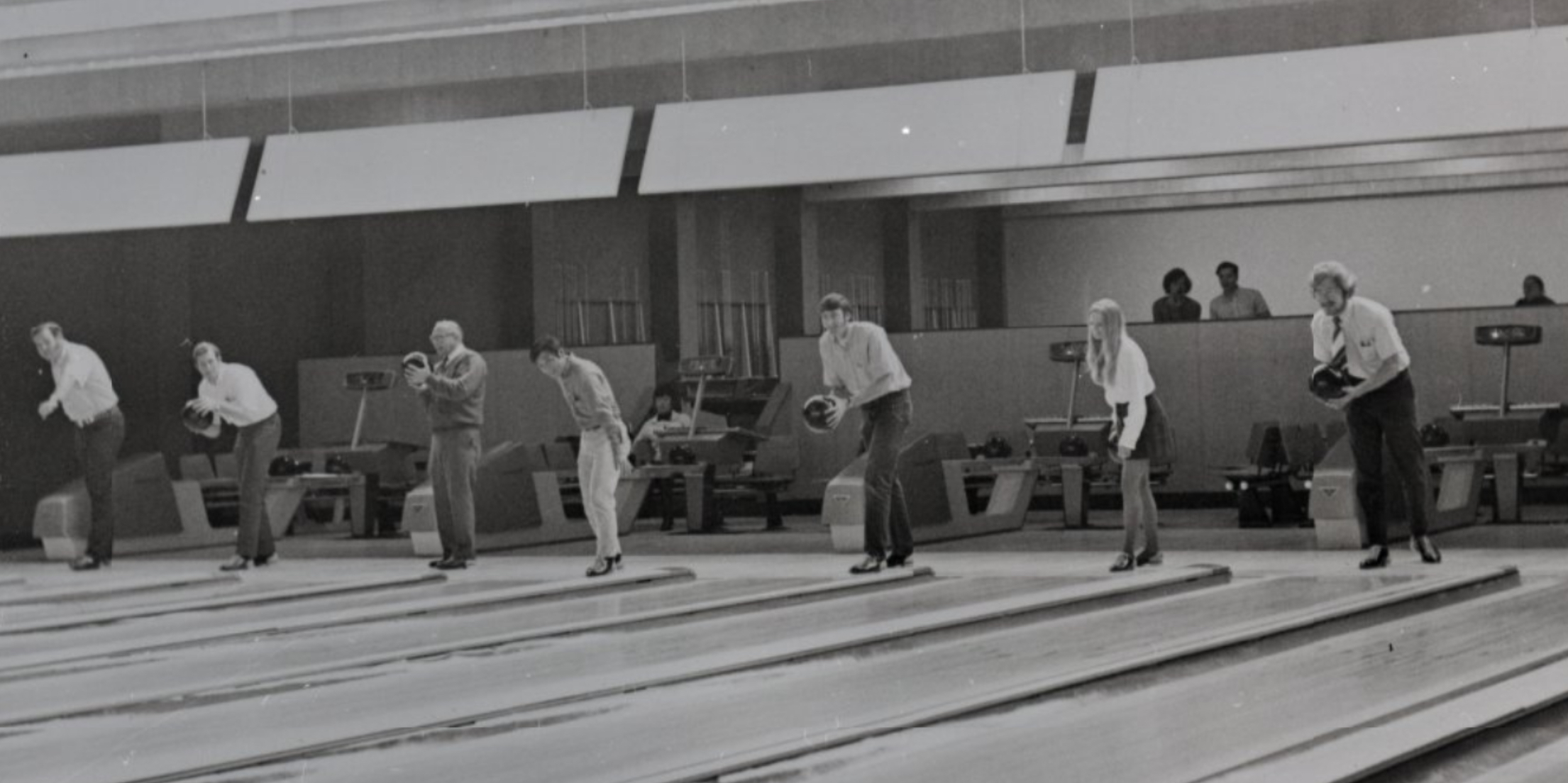 Seven students and faculty line up to bowl at the bowling alley in the University Union