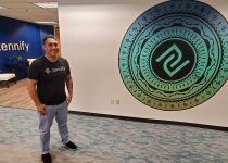 Manvir Sandhu stands in the entryway of the Zennify offices