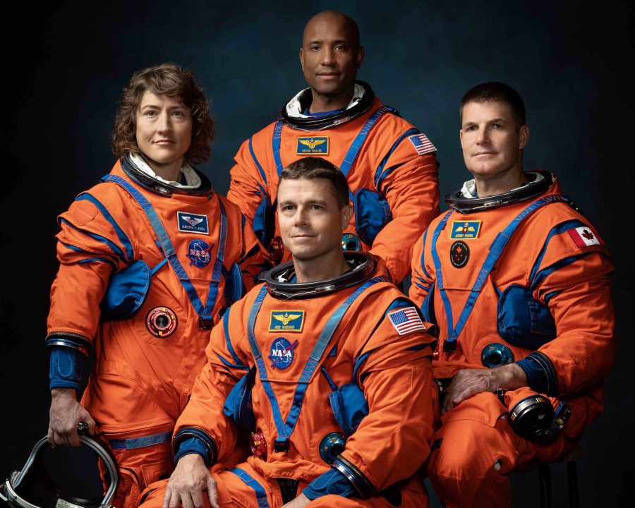 Four astronauts named to the Artemis II crew wear orange space suits