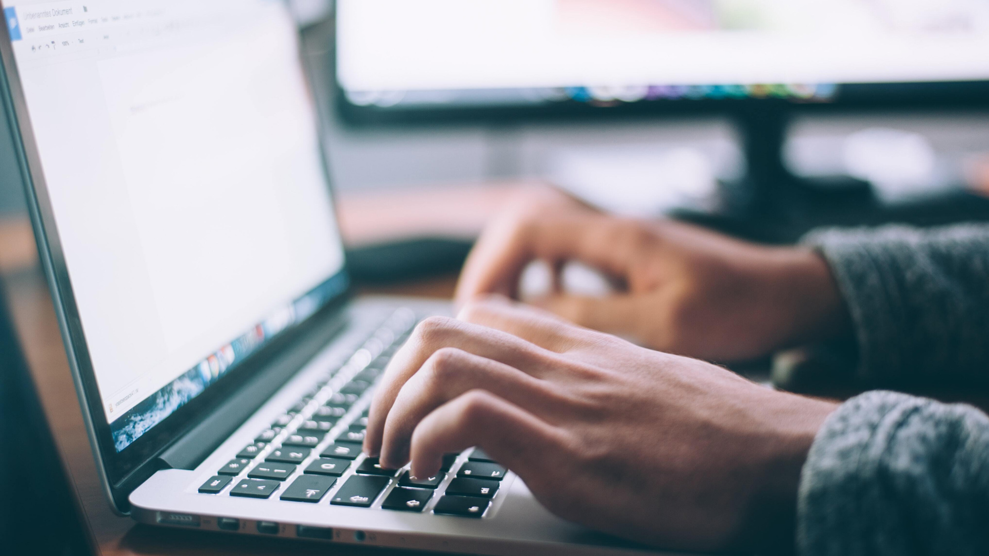 A person types on a laptop