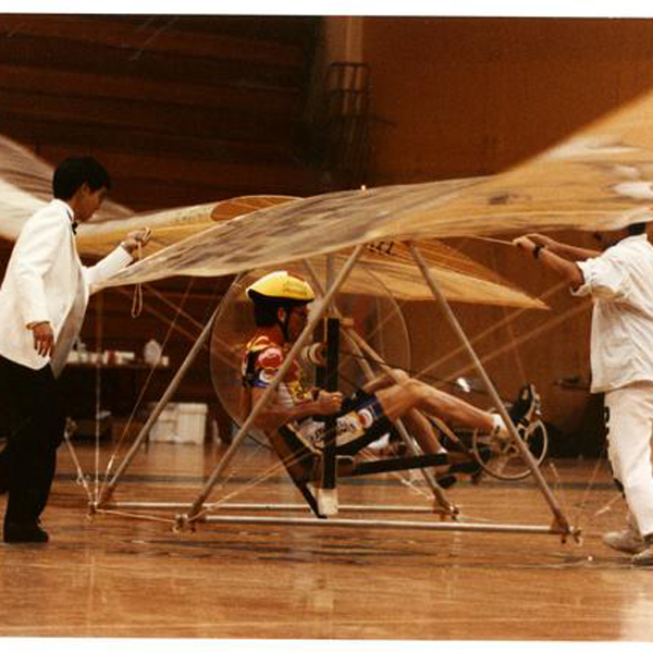 Three students test a human powered helicopter in Mott Gym at Cal Poly