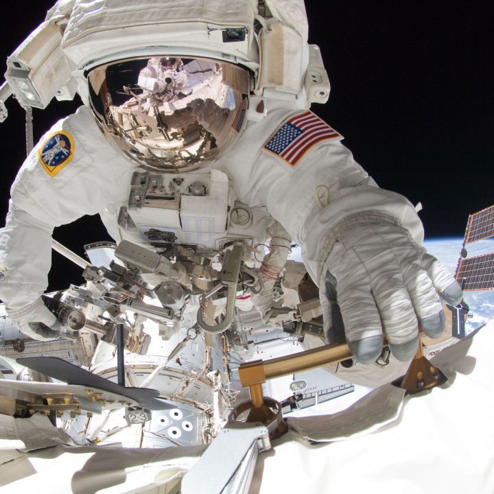 An astronaut holds onto the side of the International Space Station during a spacewalk