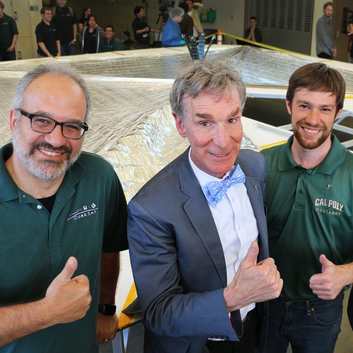 Bill Nye stands with two Cal Poly faculty in front of an unfurled mylar solar sail