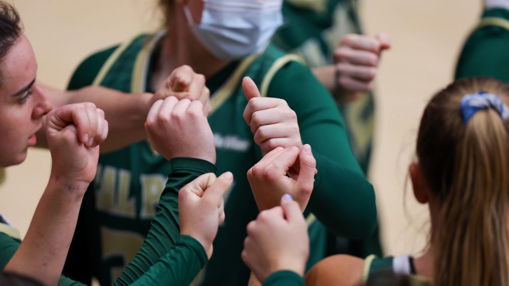 Female athletes put their hands in during a huddle