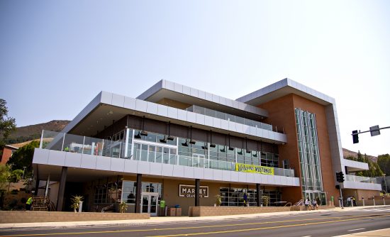 A terraced three-story building of glass, steel and brick