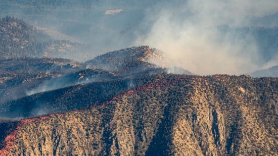 A hilside smoldering in the wake of a wildfire