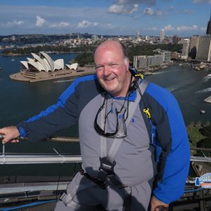 Jeff Land scales the Sydney Harbor Bridge overlooking Sydney Opera House