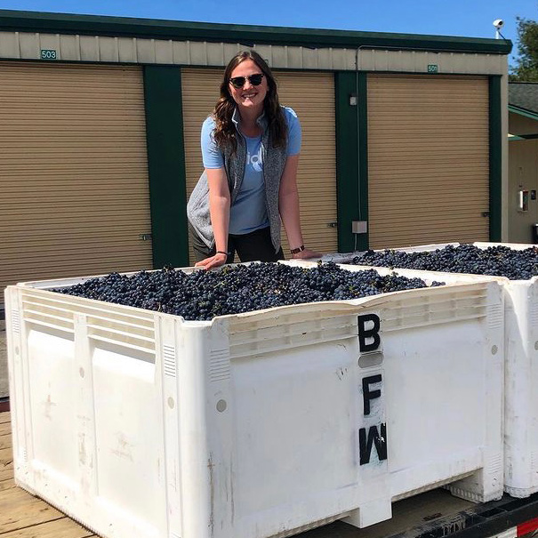 Angela Bassett smiles near a bin of wine grapes