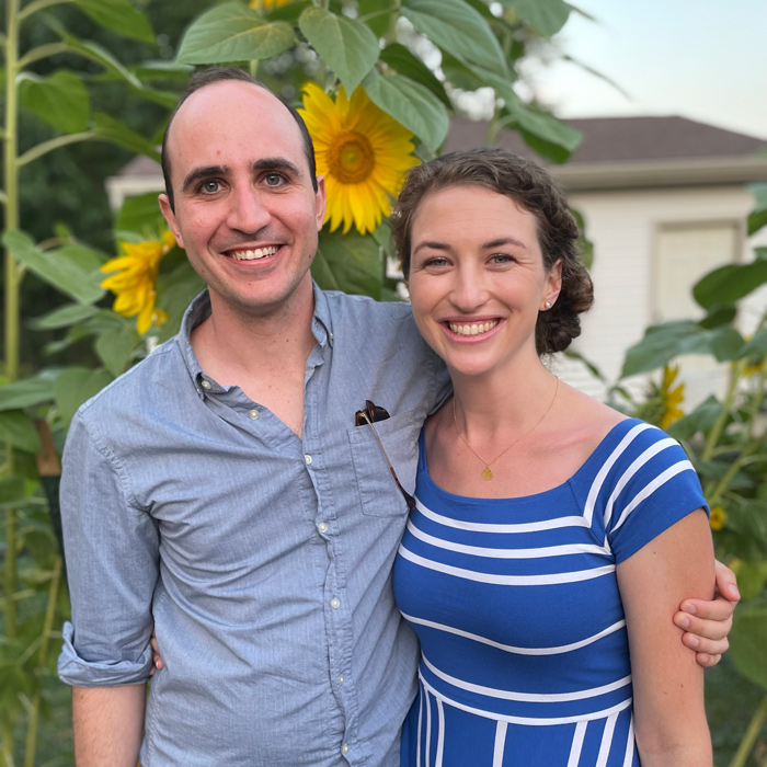 Sean and Nicole McMinn stand in front of sunflowers