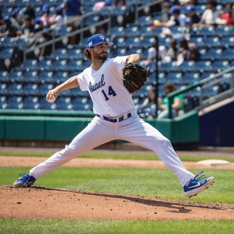 A baseball pitcher in a white jersey that says 'Isreal 14' throws the ball
