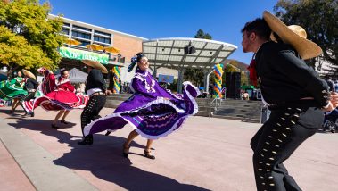 Pairs of men and women dancers in traditional Mexican clothing dance in the UU plaza