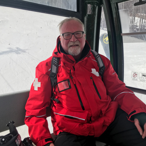 Roger Bowman wears a red ski patrol jacket