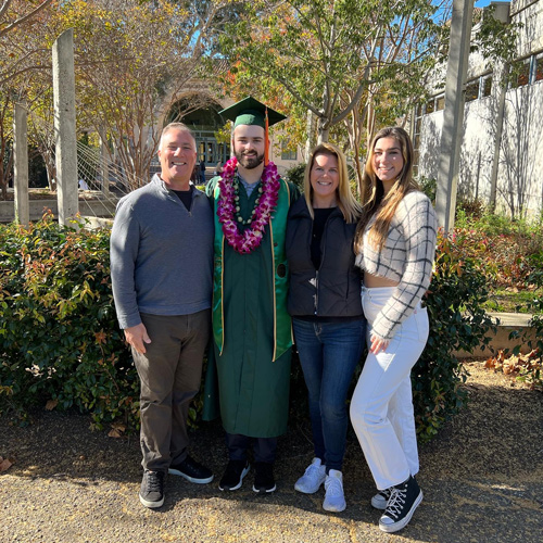 Antonio Martinucci stands in green cap and gown with three family members