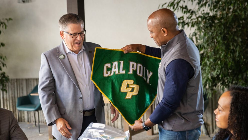 President Jeffrey D. Armstrong recives a Cal Poly banner from Victor Glover