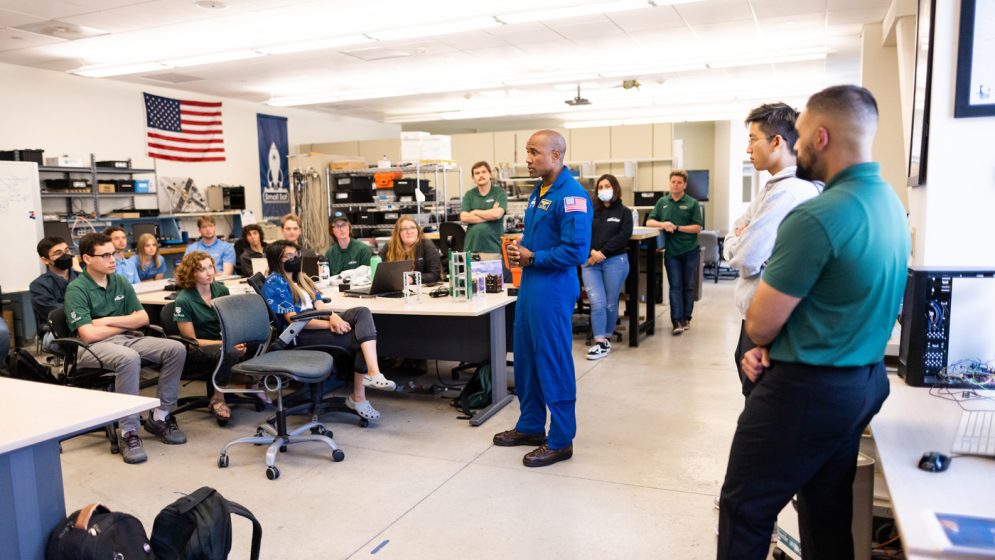 Victor Glover addresses a group of students in the CubeSat lab