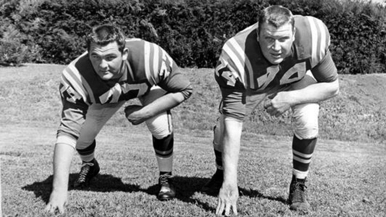 Two football players take a ready position in a black and white photo