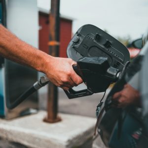 A person pumps gas into their car
