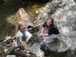 Two students examine a creek