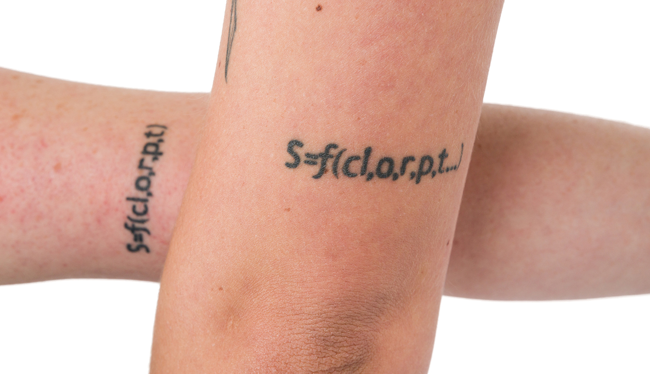 A close-up of two matching arm tattoos showing an equation