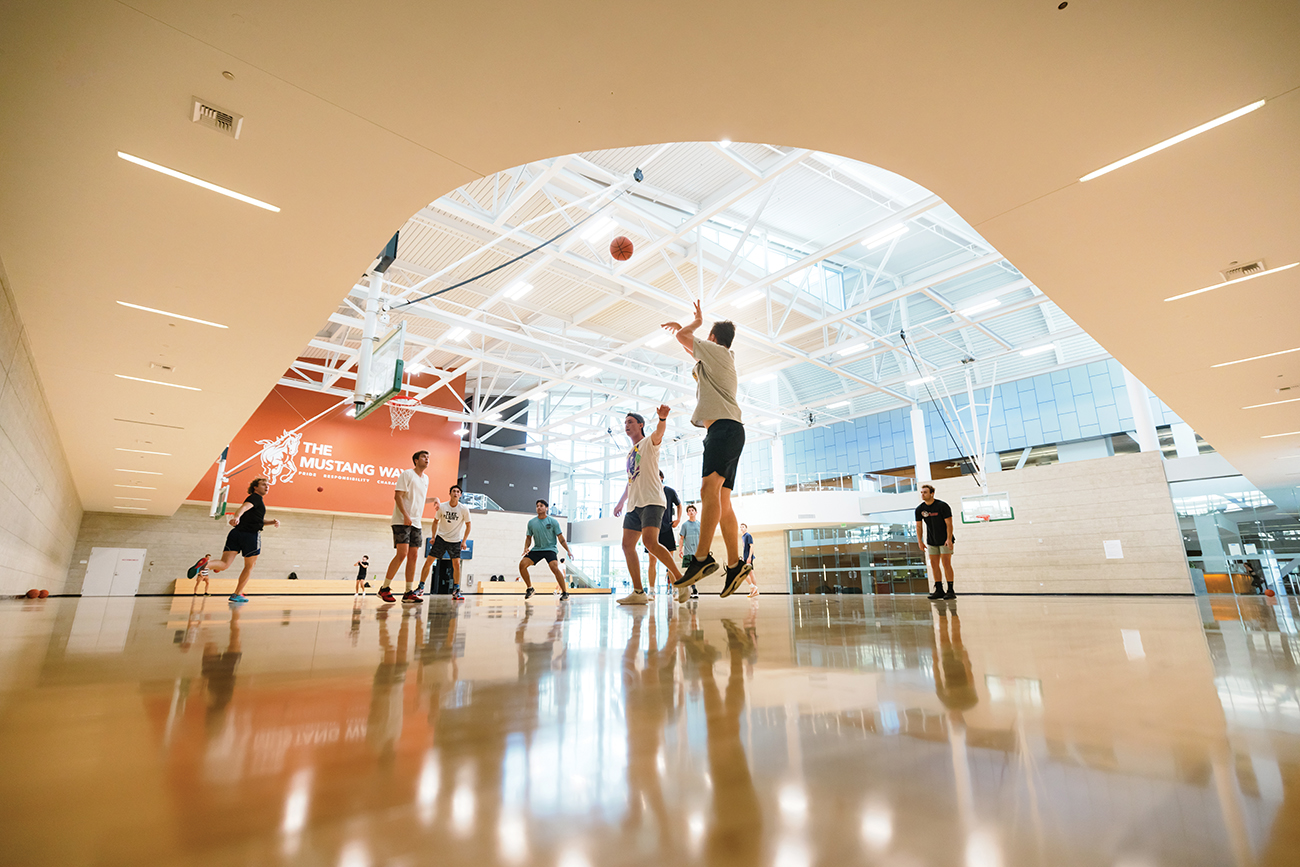 A group of young men play basketball in the Rec Center gym