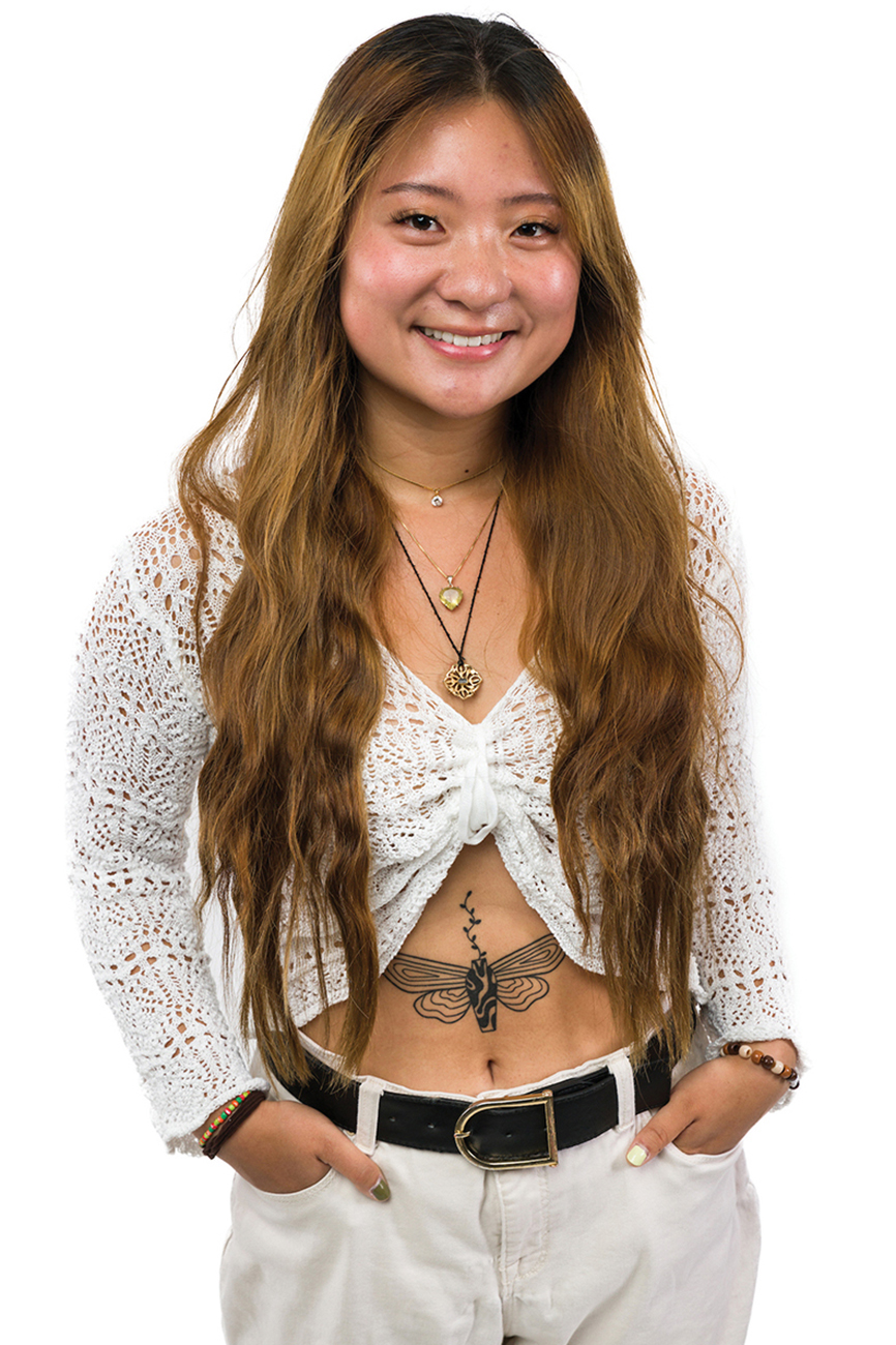 A young woman in a white top, showing off a stomach tattoo of a moth