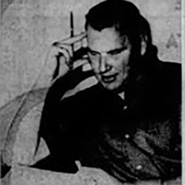 A young Madden leans over a notebook