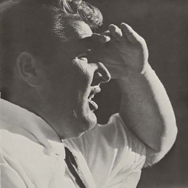 A young Madden, in shirt and tie, shades his eyes on the sidelines at an SDSU game