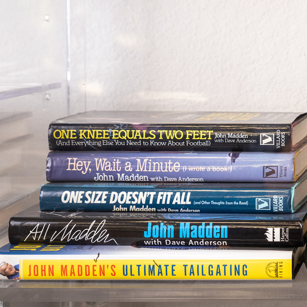A stack of colorful books authored by John Madden