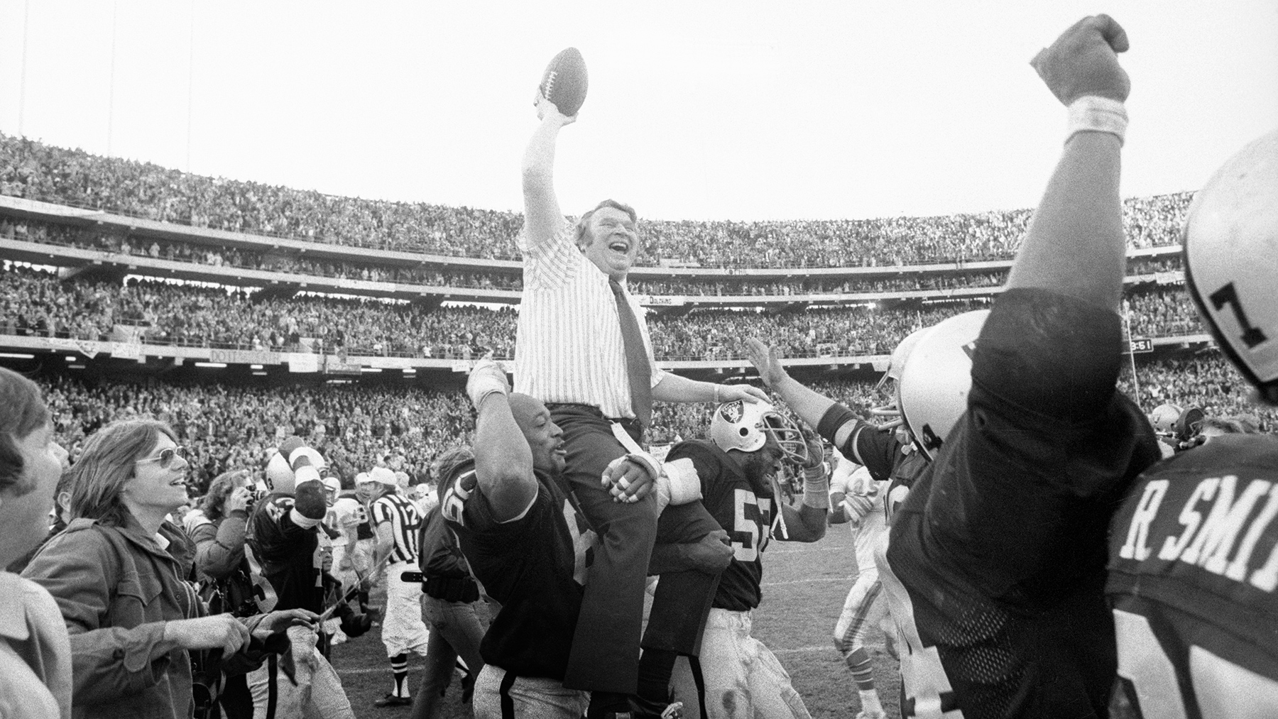 Teammates carry Madden on the field