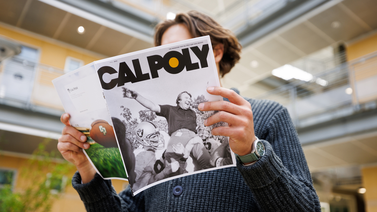 A person holds the fall issue of Cal Poly Magazine with John Madden on the cover