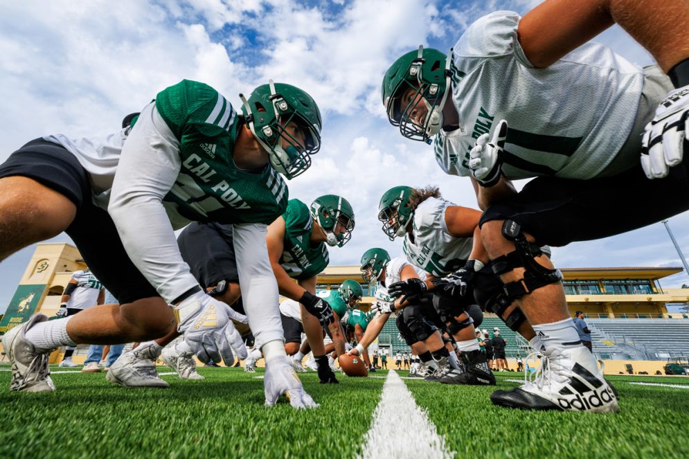 Cal Poly football players at the line of scrimmage in Spanos Stadium