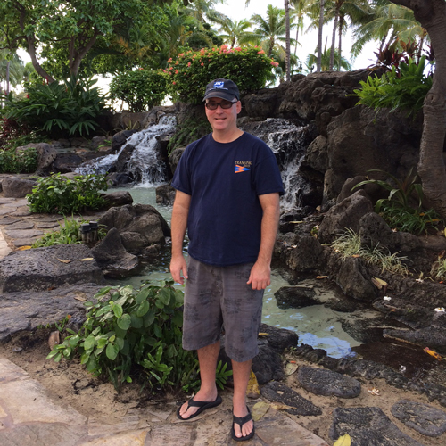 Derek Hath stands in front of a waterfall