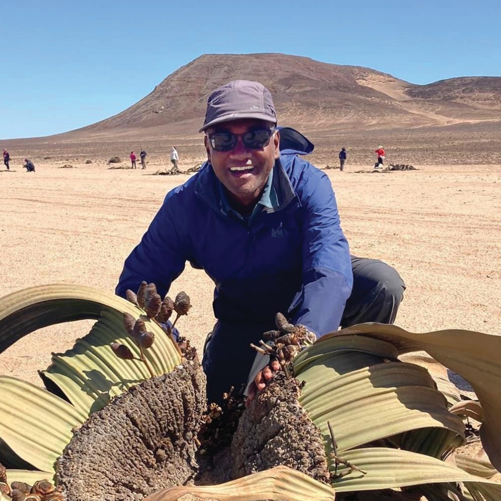 Cal Poly Professor Nishi Rajakaruna poses with a plant in the desert