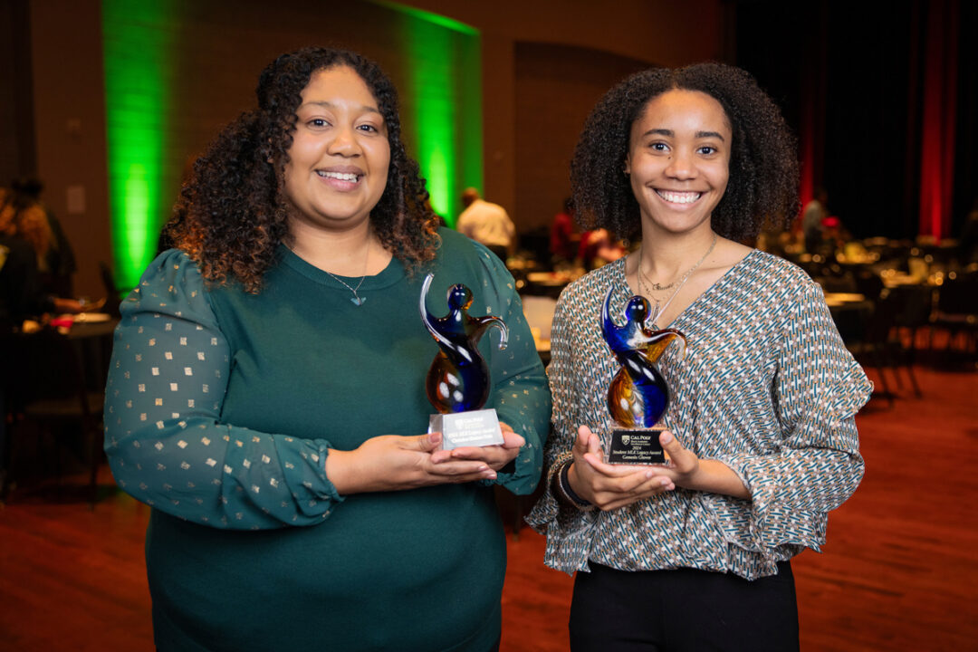 Christina Scholars Ortiz and Genesis Glover smile holding awards.