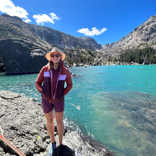 Annie O'Brien stands by a mountain lake