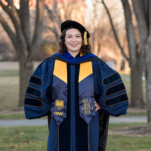 Emily Phillips in blue and gold graduation regalia