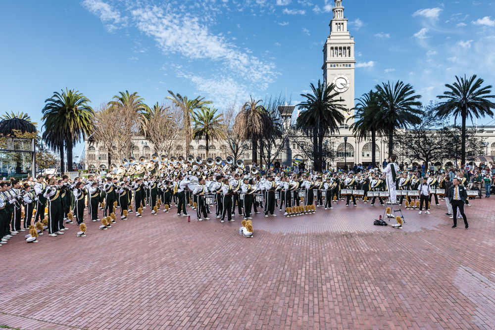 Hundreds of members of the Mustang Band play on a sunny day near San Francisco's Ferry Building.